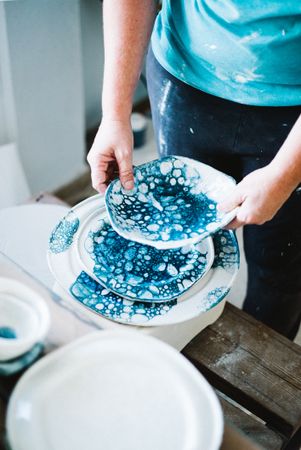 Person browsing different plates in ceramic shop