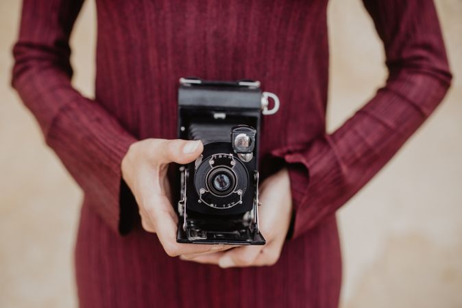 Crop lady holding vintage camera