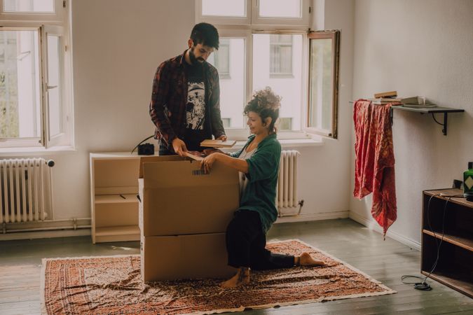 Casual couple unpacking boxes in apartment
