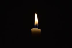 Side view of candle lit in the dark