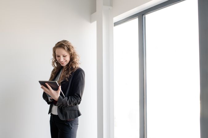 Smiling woman using tablet in office