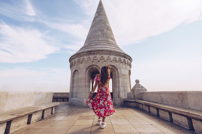Woman in colorful dress walking against old building