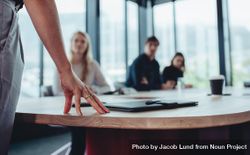 Focus on hand of businesswoman on table while talking with colleagues in boardroom 4Z6J94