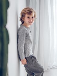 Cheerful boy standing near wall
