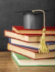 Arrangement of different books with graduation cap