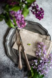 Spring table setting with lilacs on ceramic plate