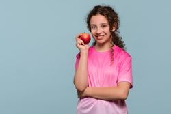Smiling young girl holding red apple