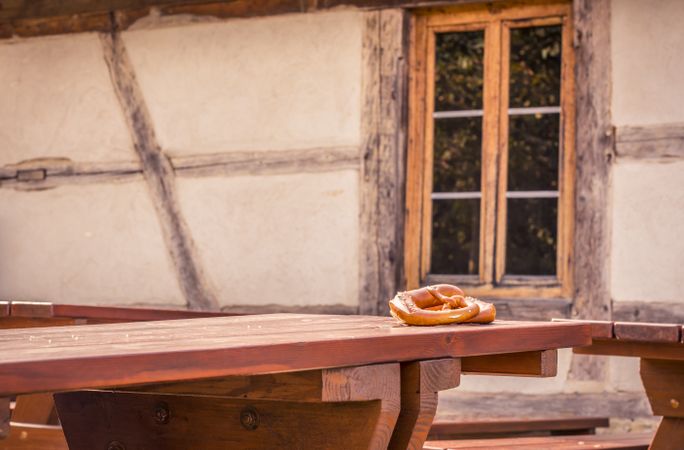 Pretzels on rustic table and German house background
