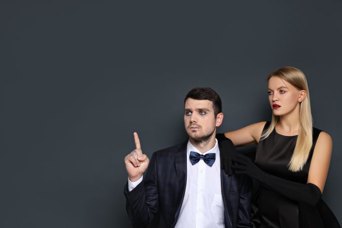 A woman and a man in Halloween costumes on a dark background