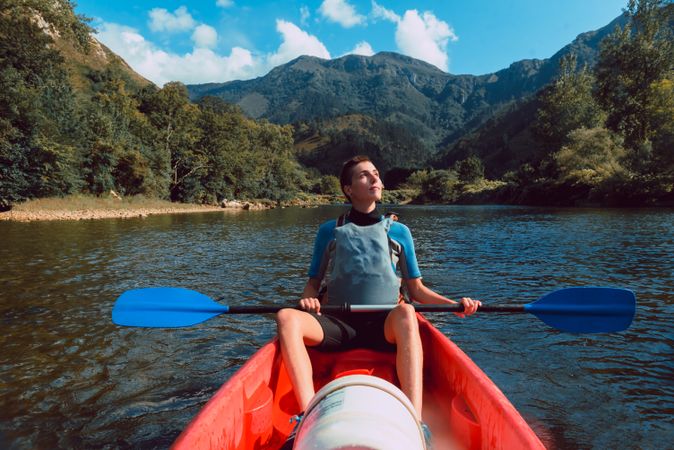 Young female kayaking on nature background