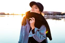 Charming woman in casual wear on shore of lake