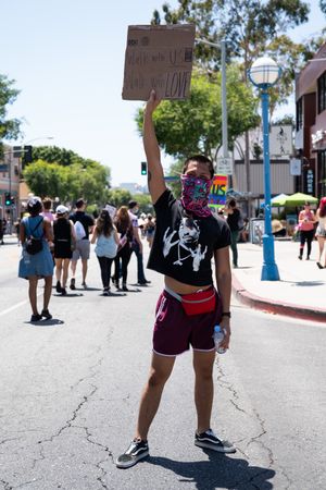 Los Angeles, CA, USA — June 14th, 2020: man standing in street holding protest sign over his head