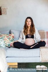 Pregnant woman sitting cross legged lounging at home 56Yxz0