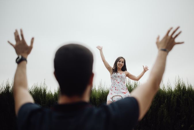Joyful couple on playground against grassy field