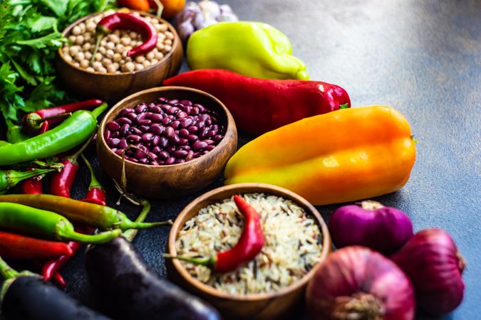 Fresh vegetables, legumes and grains on stone background with copy space