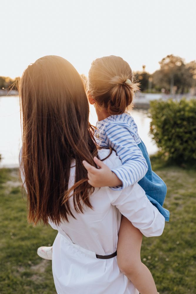 Mother and daughter standing near water