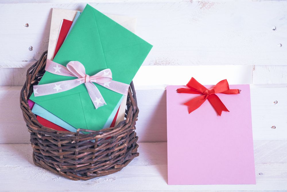 Wicker basket with letters and message cards with bows