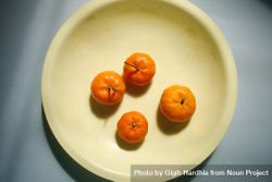 Top view of four clementines on a plate 4B6AE4