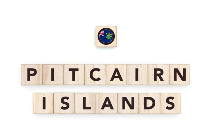 Wooden blocks bearing the name and flag of Pitcairn Islands. Pitkern and Polynesian Culture, national identity, travel, and geography in a copy space design.
