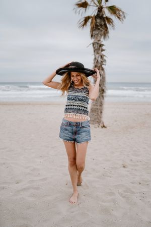 Young female relaxing on beach with hat