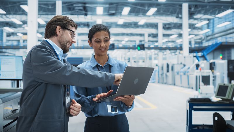 Colleagues talking in store with laptop