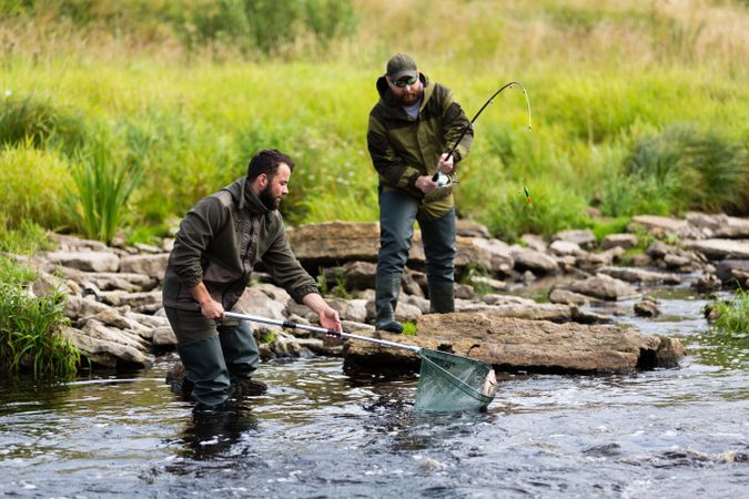 Fishermen Catching Fish Together on River