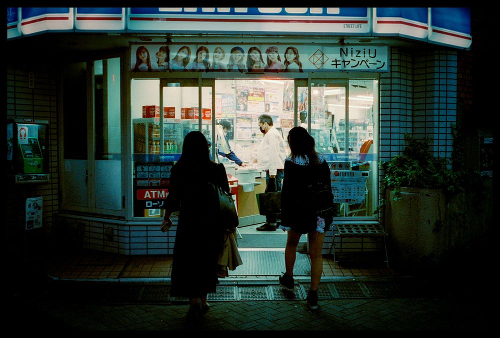 Back view of two women standing in front of store