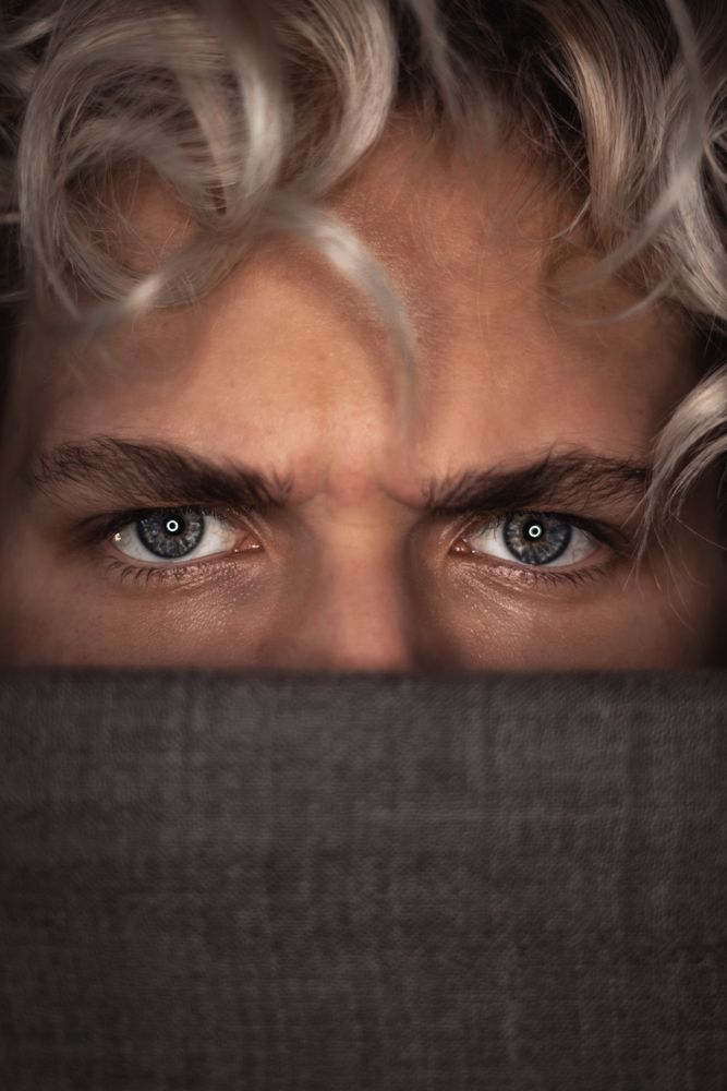 Young man's angry blue eyes