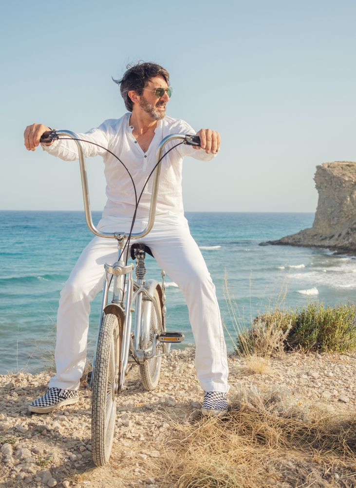 Man cycling on sandy beach hill