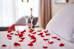 Bed with bedclothes covered with rose petals
