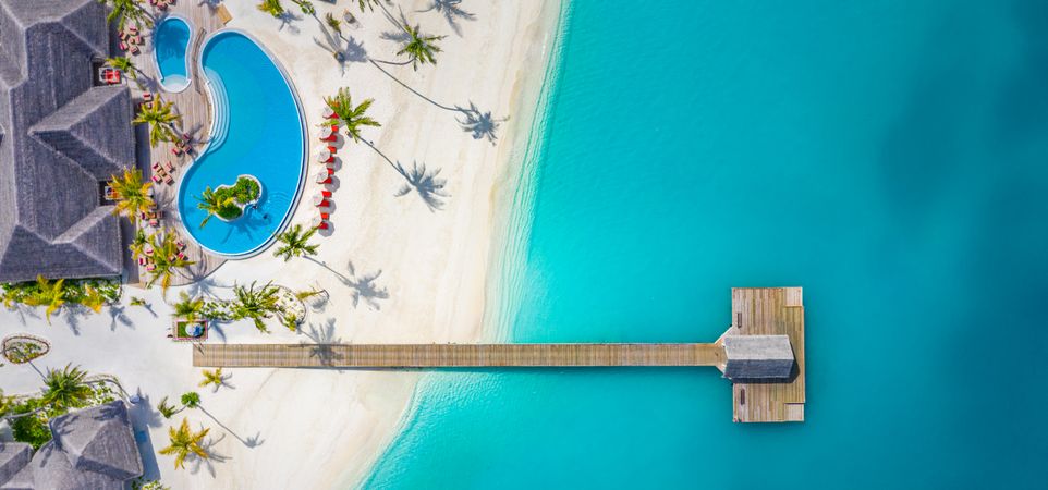 Aerial view of a pristine beach resort in the Maldives, wide