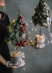 Cropped image of woman holding mini Christmas trees 5nMW20