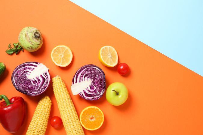 Different vegetables and fruits on two tone background, copy space