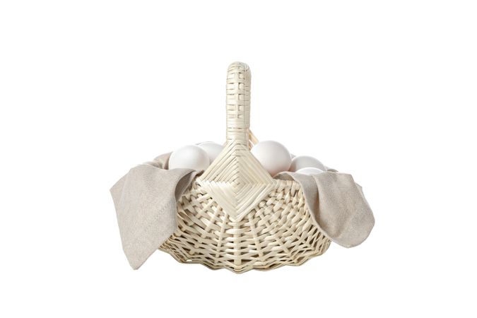 eggs in a wicker basket with handles, isolated on blank background.