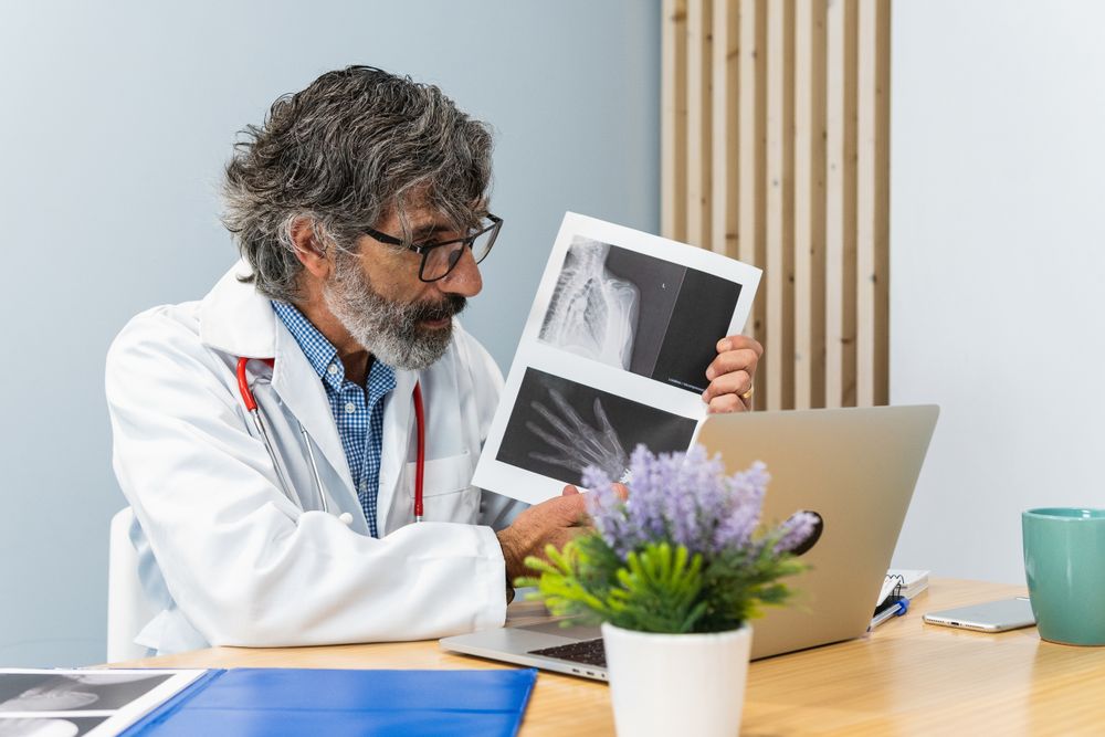 Male doctor using laptop and talking on video call
