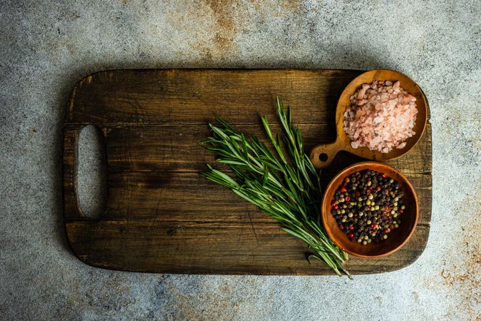 Cooking concept with spices on board on concrete background