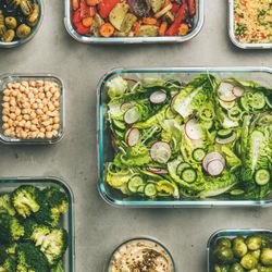 Variety of vegetable dishes arranged in glass containers, close up, square crop