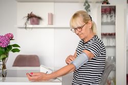 Older woman measuring blood pressure at home