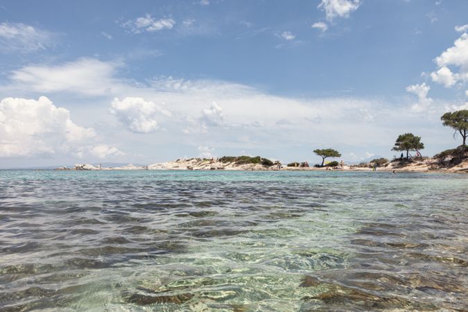 Stony island with bright greenery surrounded by water