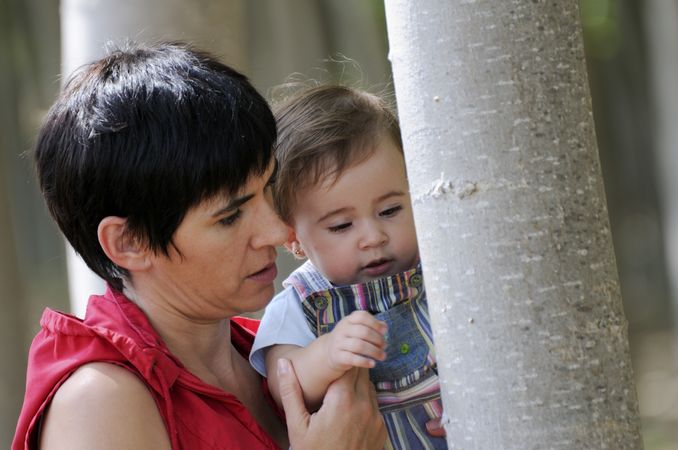 Woman and child looking intently at tree bark