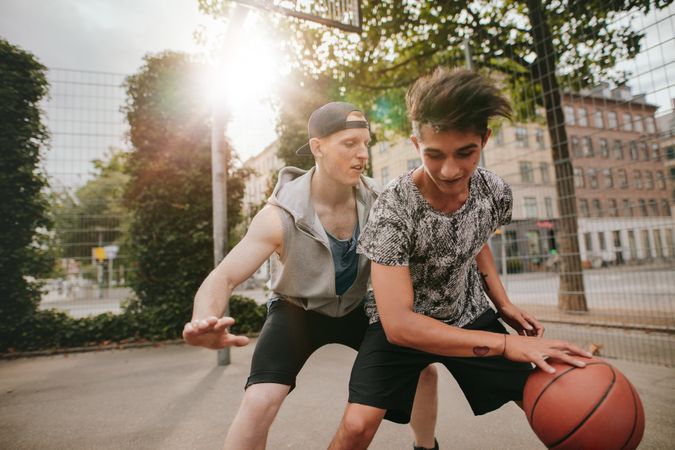 Friends playing basketball on outdoor court