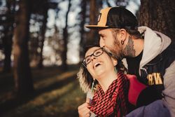Happy couple hugging near tree in park