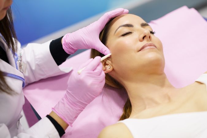 Woman having cheek prepared for cosmetic treatment