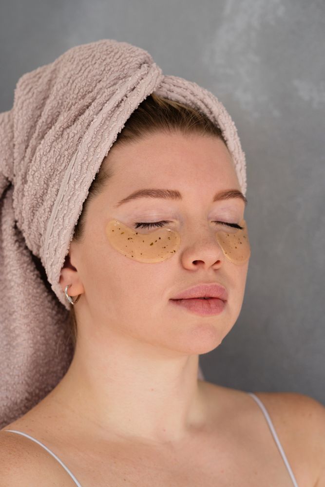 Applying eye patches in skincare routine.