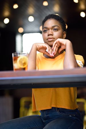 Female sitting with ice tea in modern cafe