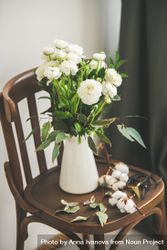 Spring buttercup flowers in enamel jug on chair 5zjEk5