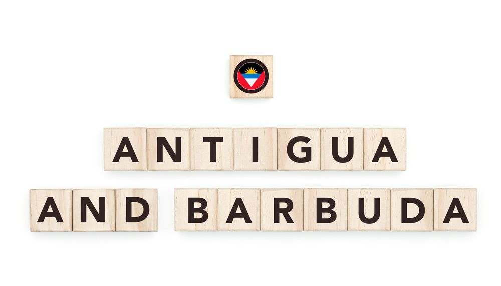 Wooden blocks bearing the name and flag of Antigua And Barbuda. Caribbean Culture, national identity, travel, and geography in a copy space design.