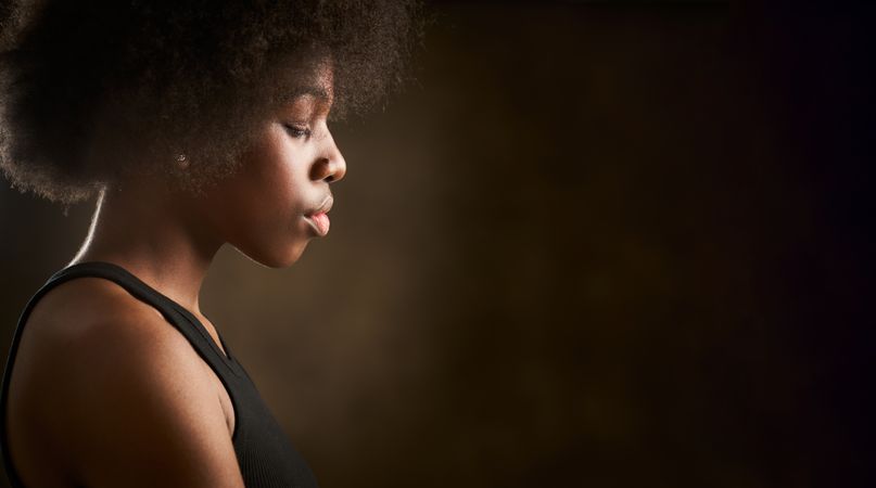 Young Black woman with afro hairstyle seen from the side