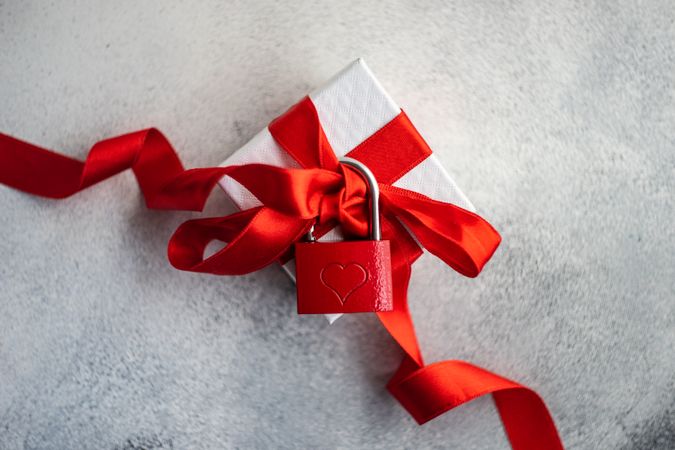 Romantic gift box with red ribbon and padlock