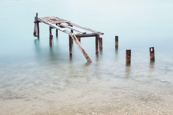 Old tires on sticks of former pier in water